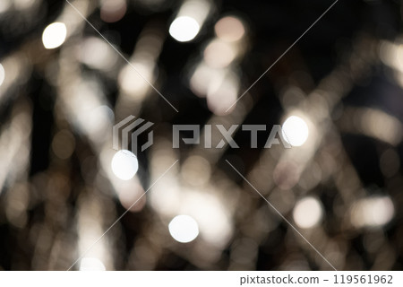 Blurry light bokeh stripes on a black background. Festive dark background. Blurry light bokeh stripes on a black background. Festive dark background. 119561962