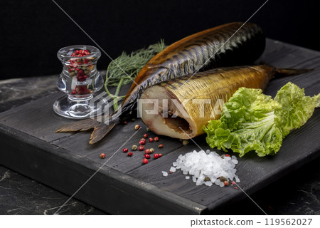 Smoked fish with herbs on a wooden board. Beautiful mackerel food. Smoked fish with herbs on a wooden board. Beautiful mackerel food. 119562027