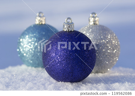Christmas blue and silver glitter decoration balls on the snow. Christmas blue and silver glitter decoration balls on the snow. 119562086