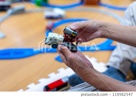 Dad changing the batteries in a Plarail train 119562547