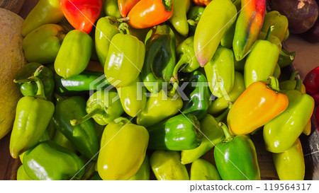 Green and yellow peppers are on the counter at the market. Vegetables 119564317