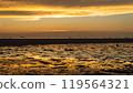 Epic sunset scene on Koh Phangan. The sun's rays illuminate the clouds and the sky is mirrored from the water and sand 119564321