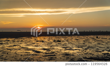 Epic sunset scene on Koh Phangan. The sun's rays illuminate the clouds and the sky is mirrored from the water and sand 119564326