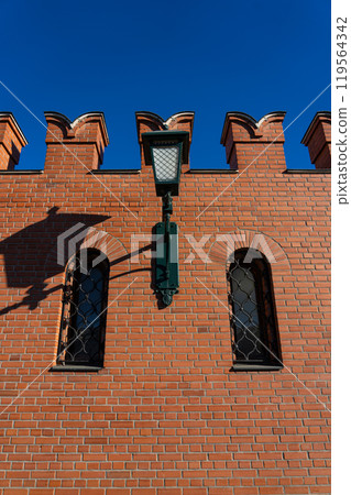 A massive, red-brick wall with small windows and a lantern A massive, red-brick wall with small windows and a lantern 119564342