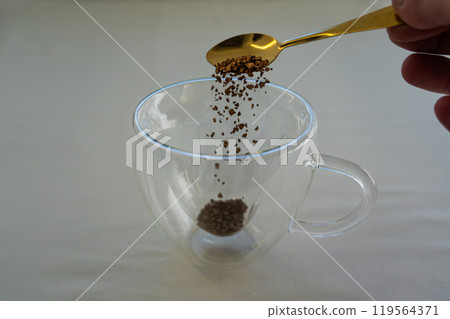 A spoonful of instant coffee in a glass mug. Coffee time. Coffee mug 119564371
