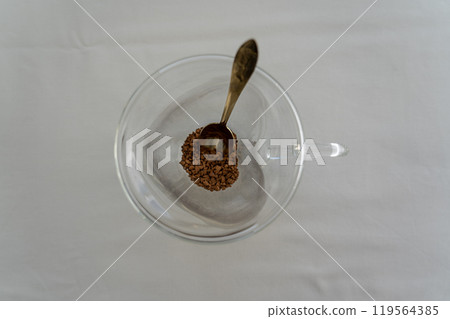 A spoonful of instant coffee in a glass mug. Coffee time. Coffee mug A spoonful of instant coffee in a glass mug. Coffee time. Coffee mug 119564385