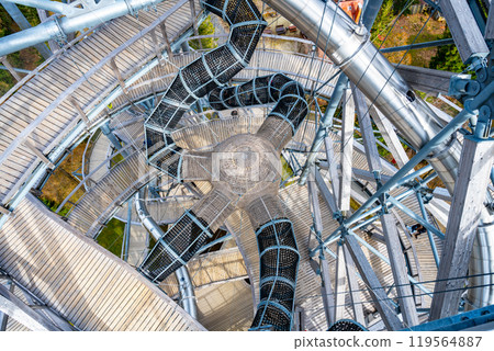 The Sky Walk Tower in Swieradow Zdroj offers a breathtaking view of the Jizera Mountains. Visitors explore a unique spiral walkway that winds its way upward amid stunning natural surroundings. The Sky Walk Tower in Swieradow Zdroj offers a breathtaking view of the Jizera Mountains. Visitors explore a unique spiral walkway that winds its way upward amid stunning natural surroundings. 119564887