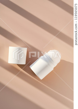 Roll-on deodorant on a purple background with shadow stripes. Roll-on deodorant on a purple background with shadow stripes. 119565073