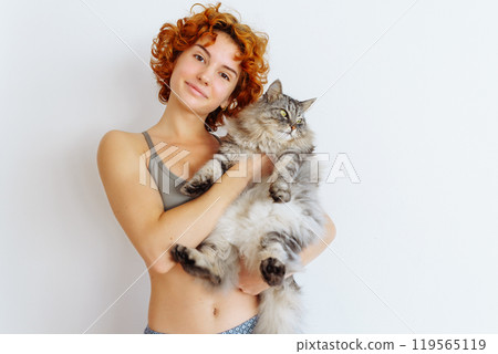 portrait red-haired teenage girl with gray fluffy cat portrait red-haired teenage girl with gray fluffy cat 119565119
