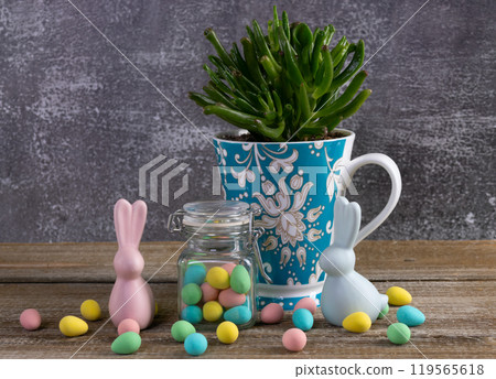 Cup with succulent, jar with Easter candies and bunny figurines. Cup with succulent, jar with Easter candies and bunny figurines. 119565618