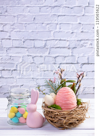 Easter nest with eggs and branches, bunny and jar with candies. 119565622