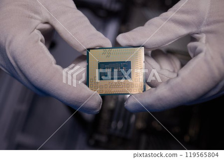 Cropped image of an engineer showing a computer microchip on the foreground 119565804