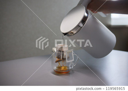 brewing process,a bag filled with boiling water for drip coffee in a cup,top view. brewing process,a bag filled with boiling water for drip coffee in a cup,top view. 119565915