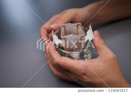 brewing process,a bag filled with boiling water for drip coffee in a cup,top view. brewing process,a bag filled with boiling water for drip coffee in a cup,top view. 119565917