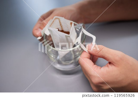 brewing process,a bag filled with boiling water for drip coffee in a cup,top view. 119565926