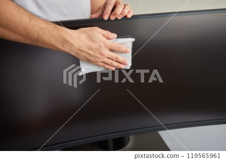 cleaning pc monitor an hand hold a rag cleaning pc monitor an hand hold a rag 119565961