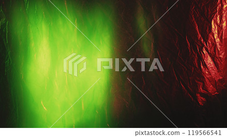 Creased foil texture. Light flare overlay. Defocused neon green color glow on red gold shiny crumpled aged foil with dust scratches abstract background. 119566541