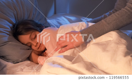 Child bedtime. Mother care. Sweet dreams. Parent love. Woman hands covering with blanket caressing peaceful cute small girl sleeping in warm cozy bed at night at home. Child bedtime. Mother care. Sweet dreams. Parent love. Woman hands covering with blanket caressing peaceful cute small girl sleeping in warm cozy bed at night at home. 119566555