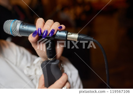 Music artist with body jewelry sings into microphone at concert Music artist with body jewelry sings into microphone at concert 119567106
