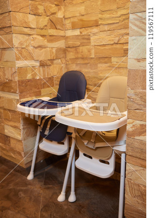 A view looking down wooden child high chairs, in a restaurant setting. 119567111