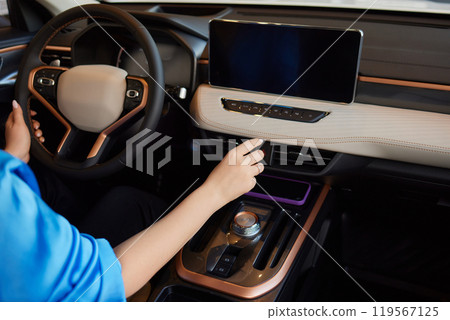 Hand of woman holding steering wheel of car 119567125