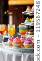 Cozy Restaurant Table with Rainbow-Themed Cupcakes on a Pristine White Platter 119567248