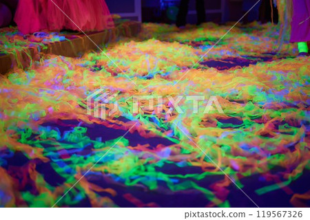 Enjoy a vibrant Neon Glow Party with colorful confetti on the dance floor under blacklight Enjoy a vibrant Neon Glow Party with colorful confetti on the dance floor under blacklight 119567326