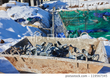 On a construction site, metal components contrast with snowy conditions in winter On a construction site, metal components contrast with snowy conditions in winter 119567345