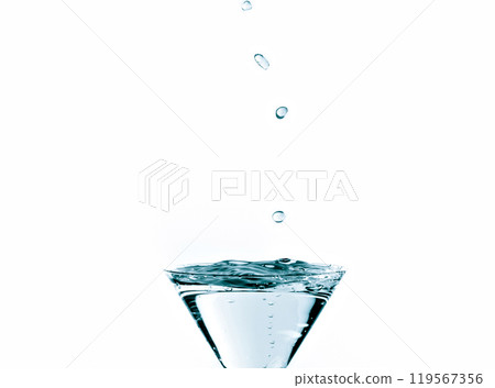 Close-up of water drop falling into a glass on white background Close-up of water drop falling into a glass on white background 119567356