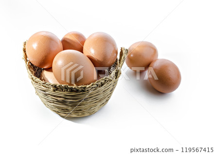 Fresh eggs inside a wicker basket on white background. Copy space 119567415