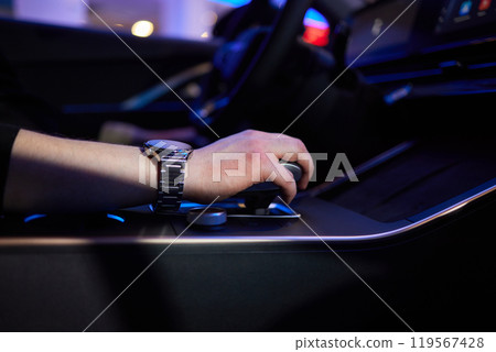 Selector automatic transmission with leather in the interior of a modern expensive car. The background is blurred. Black and brown leather car. Selector automatic transmission with leather in the interior of a modern expensive car. The background is blurred. Black and brown leather car. 119567428