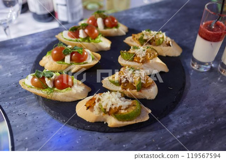 light snacks for the holiday, catering. Various light snacks. Catering plate. Assortment of sandwiches on the buffet table. meat, fish, vegetable canapes. 119567594