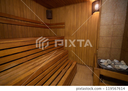 A hardwood sauna with a plank ceiling, brick wall, and stairs 119567614