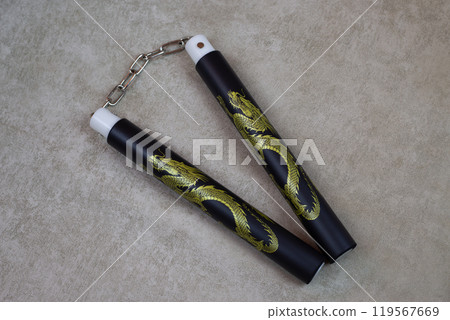 Black nunchucks with golden dragon for martial arts training, special ancient weapons for self defense. Body agility training with soft material nunchuck, martial arts culture using weapons Black nunchucks with golden dragon for martial arts training, special ancient weapons for self defense. Body agility training with soft material nunchuck, martial arts culture using weapons 119567669