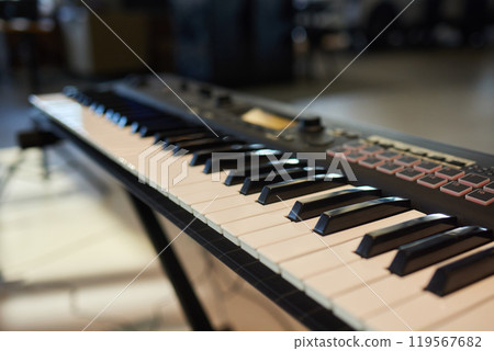 A pianist in a suit plays the keyboard with skilled hands 119567682
