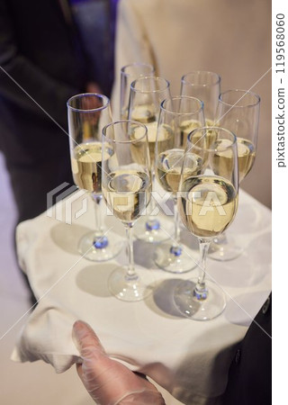 Table with champagne stemware and man in background at event Table with champagne stemware and man in background at event 119568060