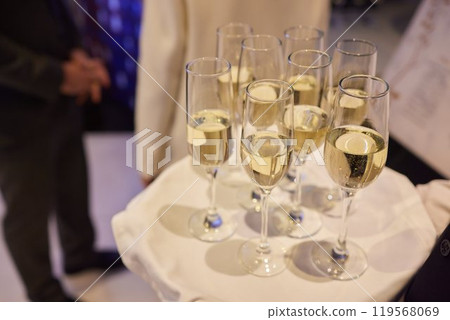 Table with champagne stemware and man in background at event 119568069