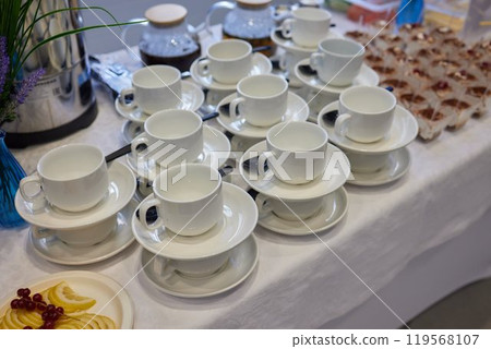 Neatly stacked white coffee cups for elegant events or catering, making a stylish presentation 119568107
