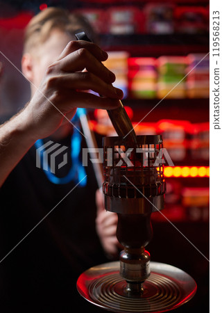 Person holding a hookah at a drinking establishment event Person holding a hookah at a drinking establishment event 119568213
