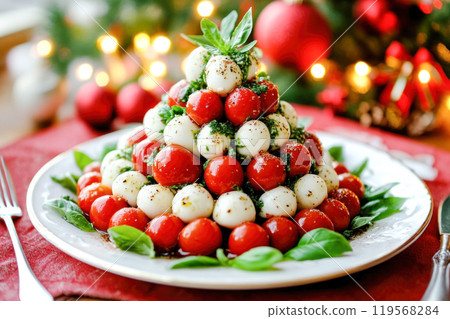 Italian caprese salad with tomatoes, mozzarella cheese and basil leaves arranged in the shape of Christmas tree 119568284