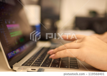 A closeup showing hands typing on a laptop keyboard, with an engagement ring on the finger A closeup showing hands typing on a laptop keyboard, with an engagement ring on the finger 119568401