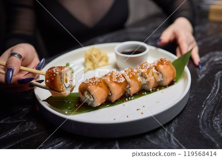 Sushi dish on white plate with sauce, table setting 119568414