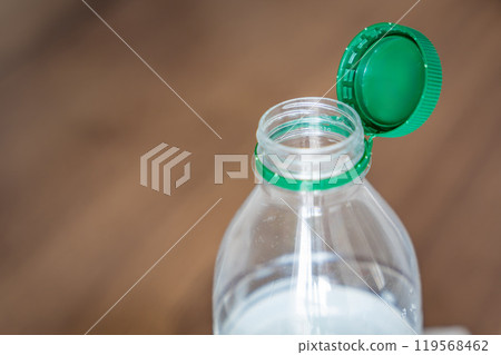 Stationary plastic cap on a PET bottle. The new design means the cap remains attached to the bottle after opening, making the entire package easier to collect and recycle Stationary plastic cap on a PET bottle. The new design means the cap remains attached to the bottle after opening, making the entire package easier to collect and recycle 119568462