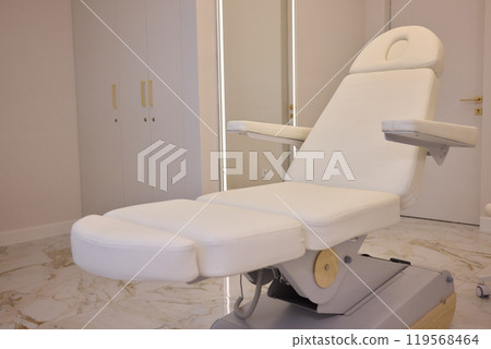 Modern spa with white massage chair and luxurious marble flooring for serene relaxation Modern spa with white massage chair and luxurious marble flooring for serene relaxation 119568464