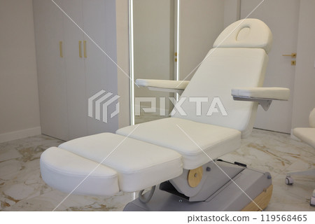 Modern spa with white massage chair and luxurious marble flooring for serene relaxation Modern spa with white massage chair and luxurious marble flooring for serene relaxation 119568465
