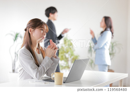 Business people arguing with each other and a woman who can't concentrate on her work because she's worried about their conversation_2 Business people arguing with each other and a woman who can't concentrate on her work because she's worried about their conversation_2 119568480