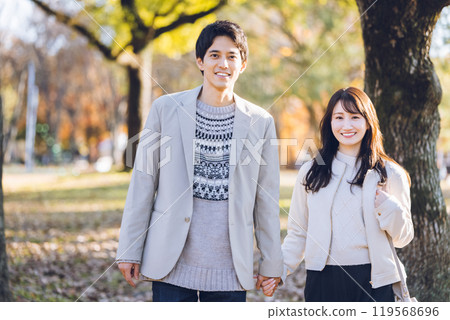 A couple walking in the park enjoying the autumn leaves 119568696