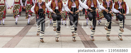 Dancers in vibrant costumes performing Traditional folk dance on an outdoor Dancers in vibrant costumes performing Traditional folk dance on an outdoor 119568860