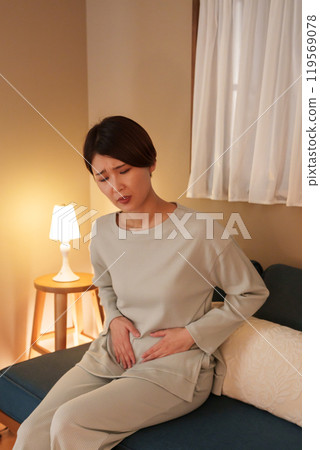 Middle-aged woman with stomach ache at night 119569078