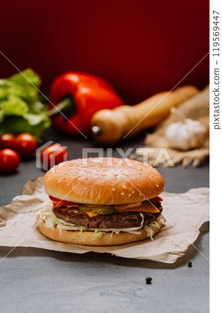 Fresh and juicy cheeseburger with toppings and vegetables on a sesame bun, ideal for food lovers Fresh and juicy cheeseburger with toppings and vegetables on a sesame bun, ideal for food lovers 119569447